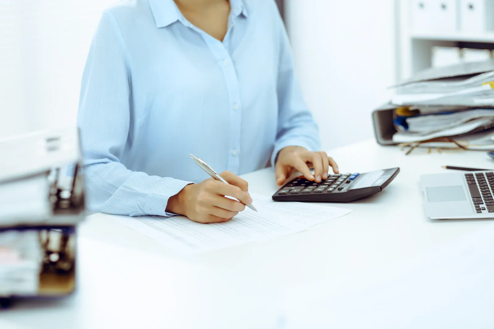 Profesional revisa documentación contable y realiza cálculos