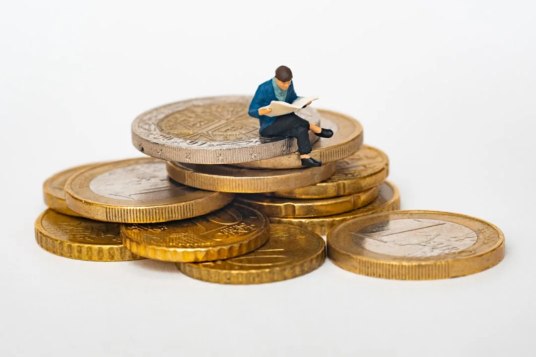 Figura leyendo sobre monedas de euro, símbolo de analizar la fiscalidad al vender una LLC desde España con Barcelona Tributario