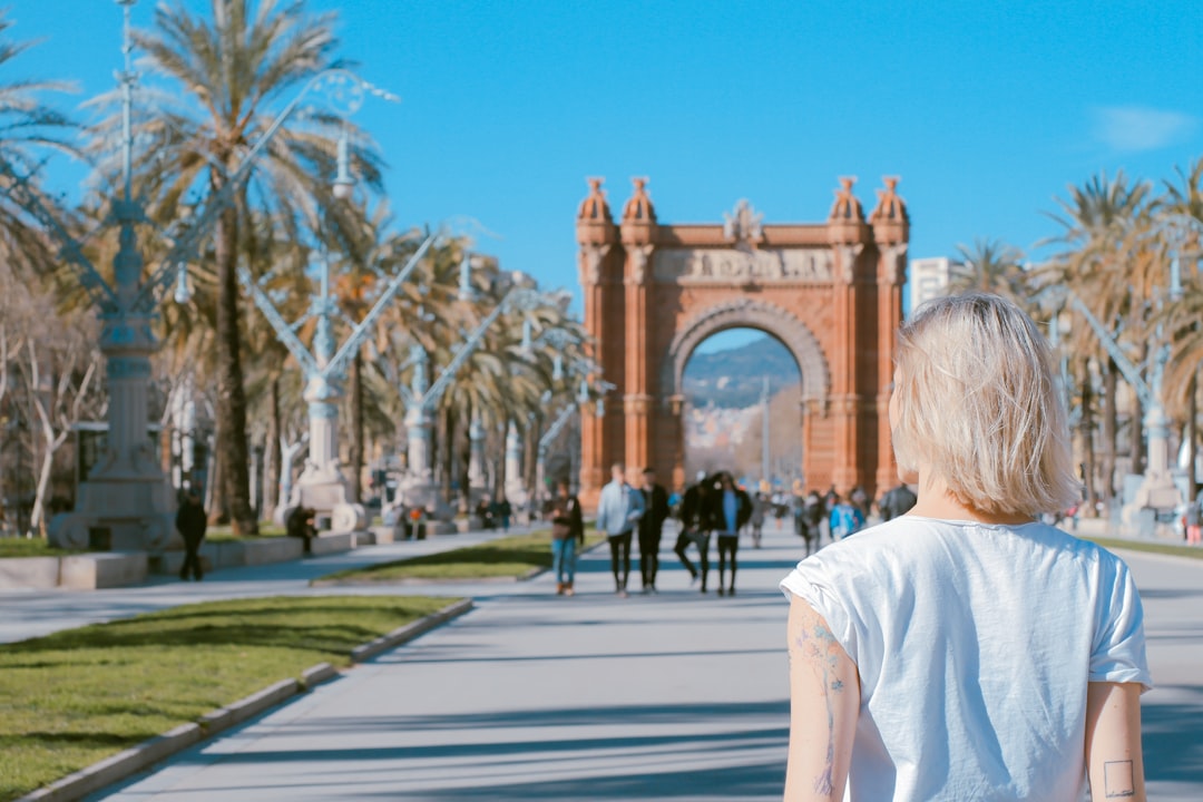 Mujer con pensión extranjera frente al Arco de Triunfo de Barcelona, donde Barcelona Tributario asesora antes del traslado